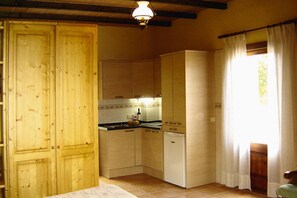 A compact kitchen with wooden cabinets, a built-in oven, and a refrigerator. - Finca in Muro with Panoramic Views (Santa Margalida)