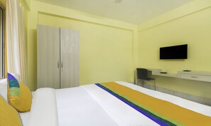 A hotel room with a bed, a wardrobe, a television, and a desk. - Treebo Trip Flama House (Baruipur)