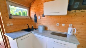 A compact kitchen with a window, a sink, a kettle, and a microwave. - Single-story, year-round holiday home (Ustronie Morskie)