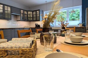 Enjoy a functional kitchen with modern cabinetry, a dining table, and appliances.