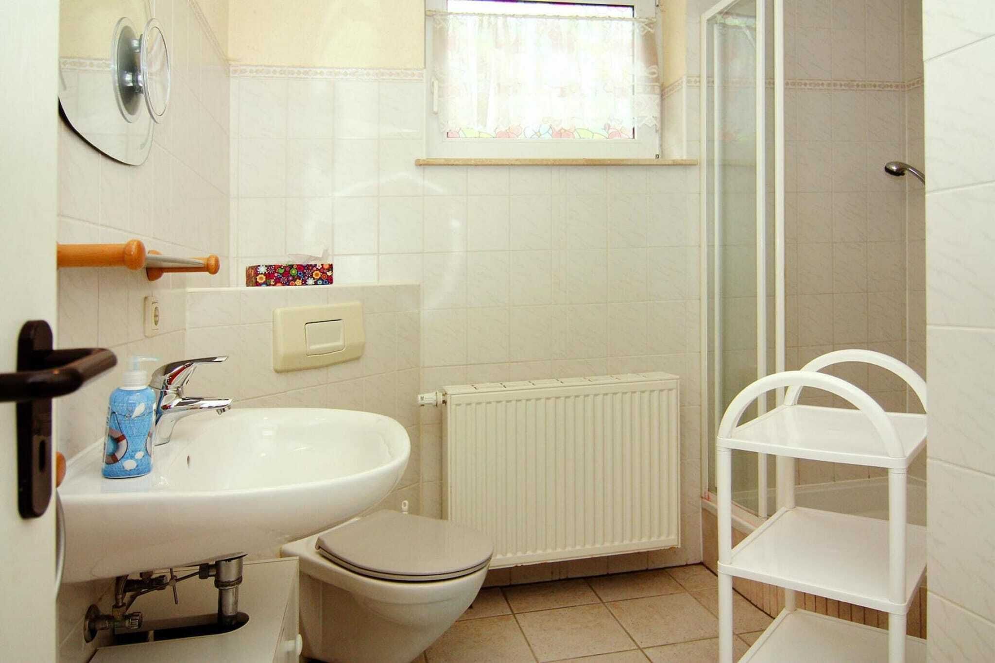 Een badkamer met een wit wastafel, toilet en douchehoek.