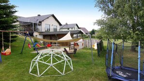 A backyard with a swing set, a trampoline, and a playhouse. - Ferienwohnung, Zemitz (Zemitz)