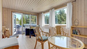 A cozy room with a foosball table, wicker chairs, a glass table, and large windows offering a view of the outdoors. - Awesome home in Væggerløse with WiFi (Væggerløse)