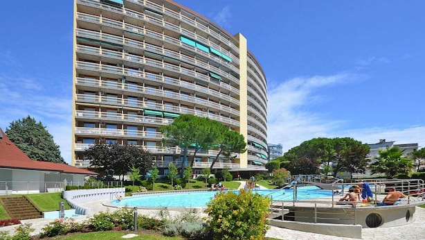 Un hotel de varios pisos con piscina y zona de estar al aire libre.