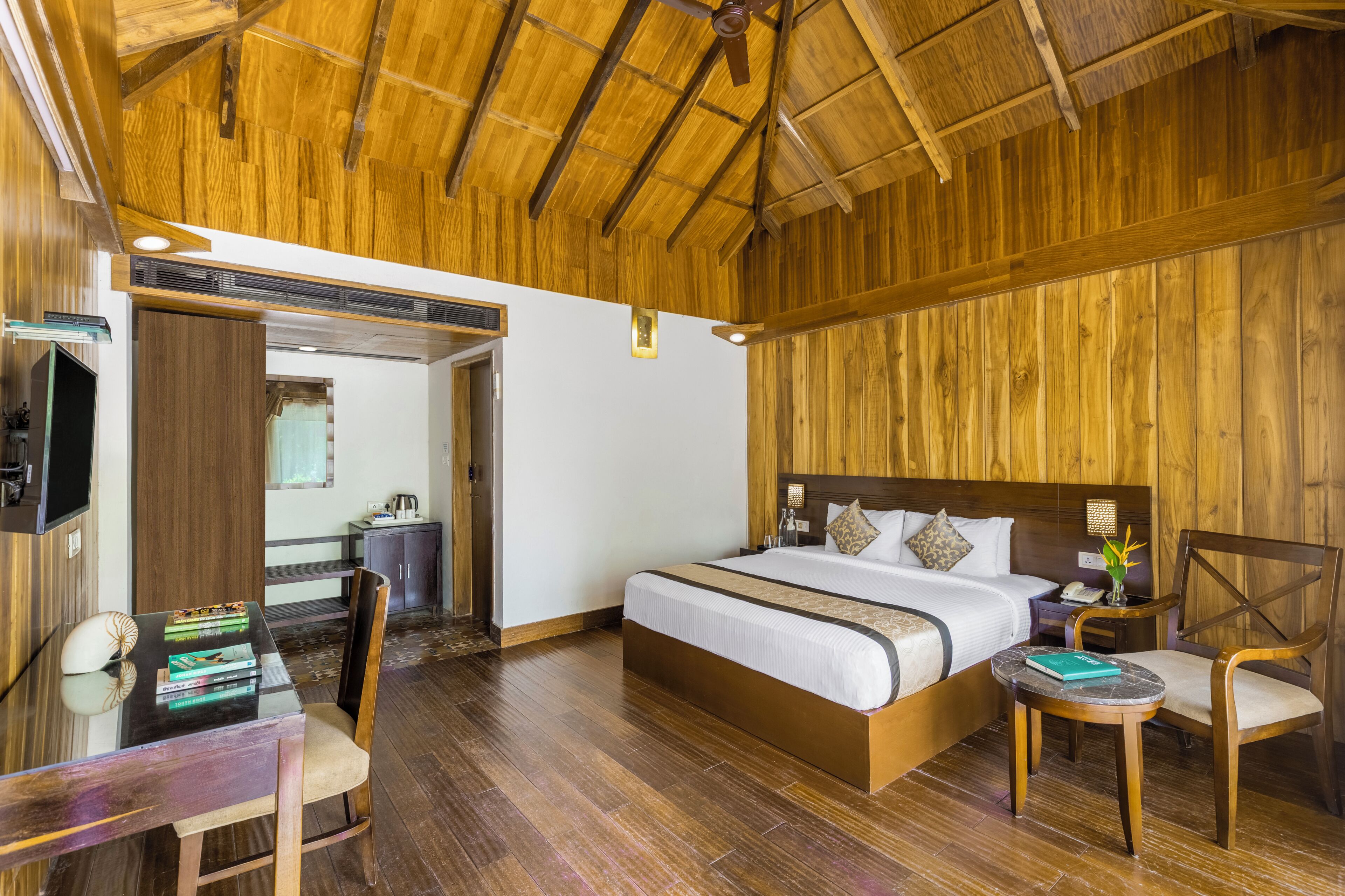 Une chambre d’hôtel à thème, décorée dans un style boisé, comprenant un lit, un bureau et une chaise.