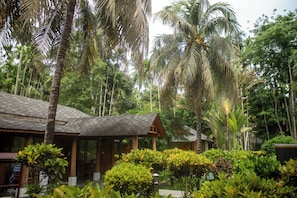A tropical resort with a wooden building, lush greenery, and palm trees. - TSG Blue Resort and Spa (Port Blair)