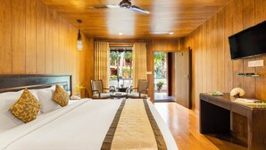 Habitación de hotel con cama, escritorio, televisión y vistas al exterior.