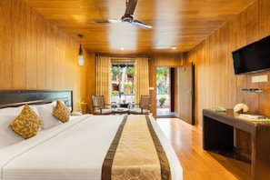 A hotel room with a bed, a desk, a television, and a view of the outdoors. - TSG Blue Resort and Spa (Port Blair)
