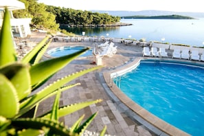 A pool area with lounge chairs and a view of the lake.