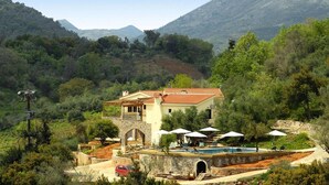 A Mediterranean-style villa with a swimming pool, outdoor seating, and a view of the surrounding hills. - Romantic Holiday Home in Drosia (Drosia)