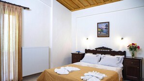 A hotel room with a bed, a nightstand, a painting on the wall, and a window with curtains. - Romantic Holiday Home in Drosia (Drosia)