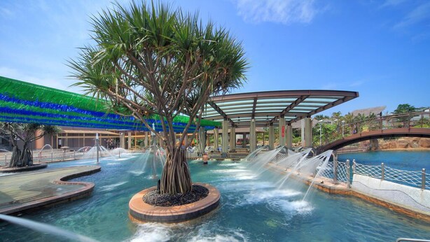 A water feature with a central tree, a pool, and a covered area with a glass roof. - Jin Yong Quan Spa Hotspring Resort (New Taipei City)