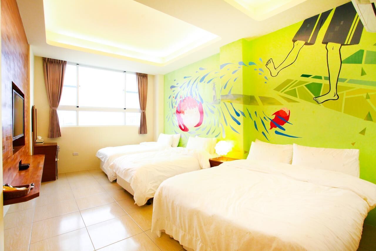 Habitación de hotel con dos camas, un televisor, un escritorio y un ventanal grande.
