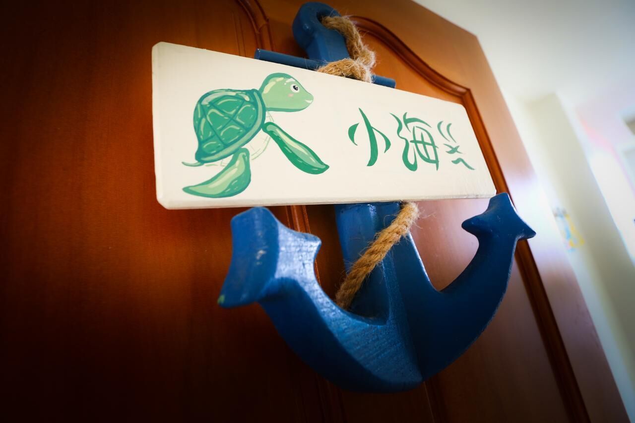 Una puerta de madera con un ancla azul y un letrero que muestra una tortuga y caracteres chinos.