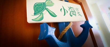 Una puerta de madera con un ancla azul y un letrero que muestra una tortuga y caracteres chinos.