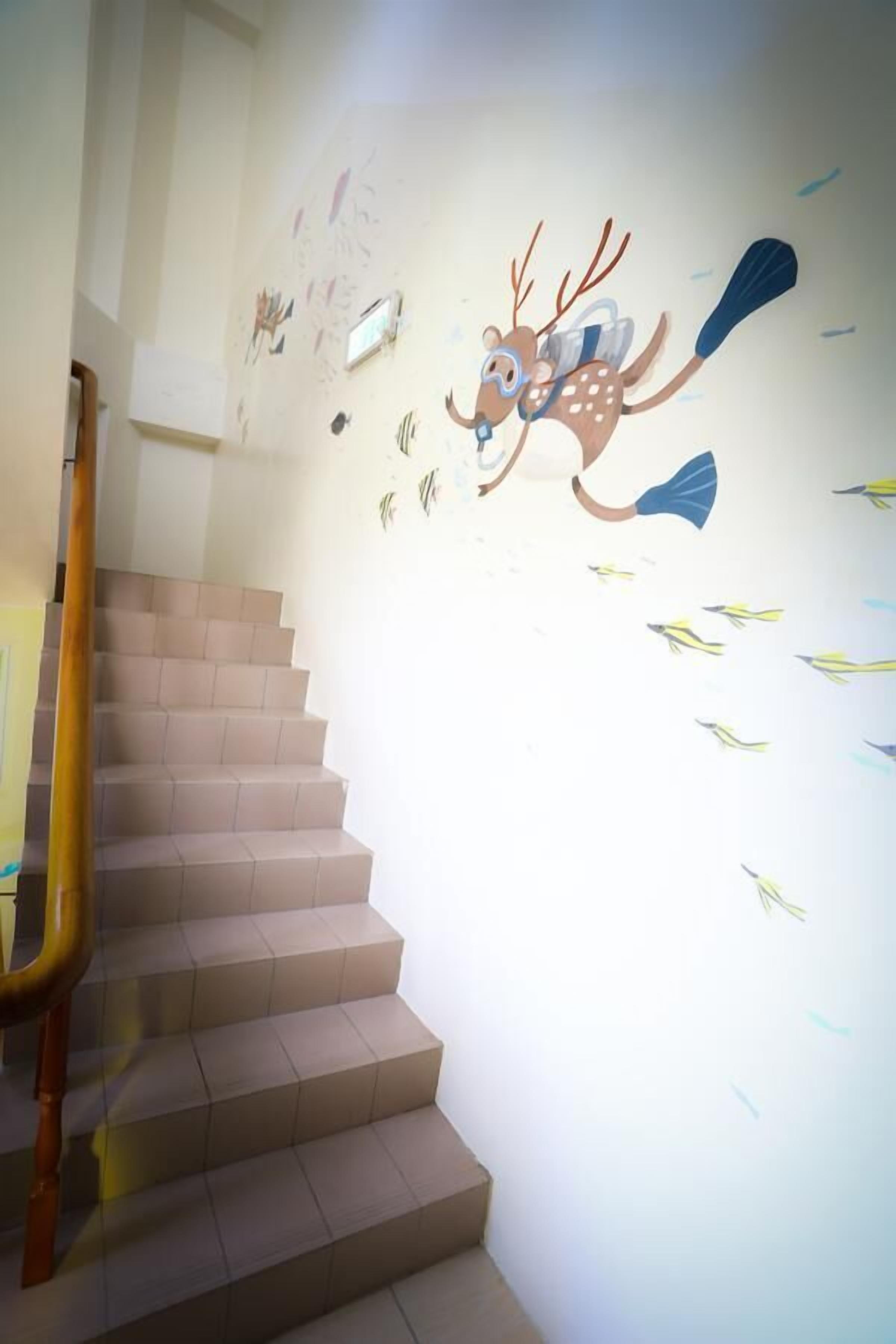 Una scala con gradini color beige e una ringhiera in legno.
