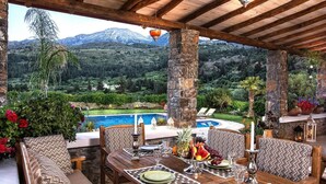 A dining area with a view of a mountain and a pool. - Private Pool & Garden Villa for 6 (Pemonia)