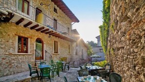 Un bâtiment en pierre doté d’une terrasse et d’un balcon.
