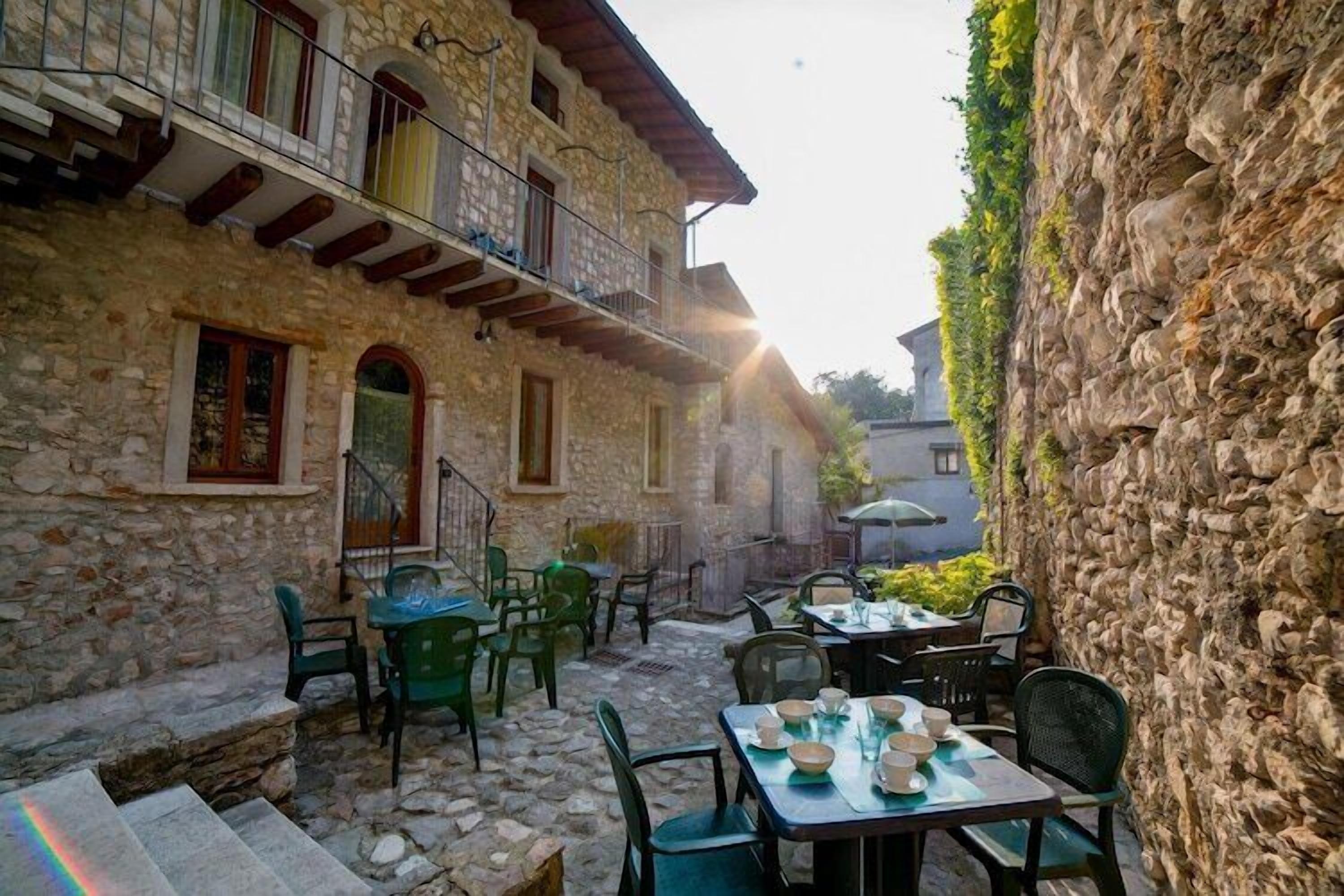 Un bâtiment en pierre doté d’une terrasse, d’un balcon et d’un escalier menant à l’étage supérieur.