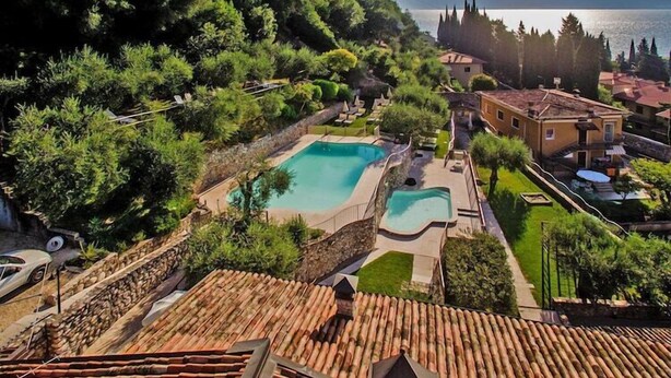 Une villa avec piscine, un toit-terrasse et vue sur la mer.