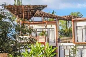 Un bâtiment comprenant plusieurs pièces, un balcon et une toiture en chaume.