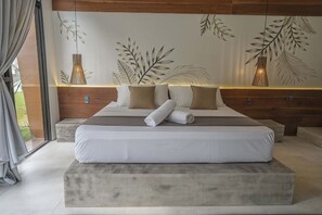 Une chambre moderne avec un grand lit, une tête de lit en bois et une vue sur l’extérieur.
