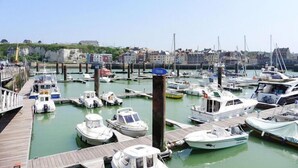 Un port de plaisance où diverses embarcations sont amarrées à des quais en bois.