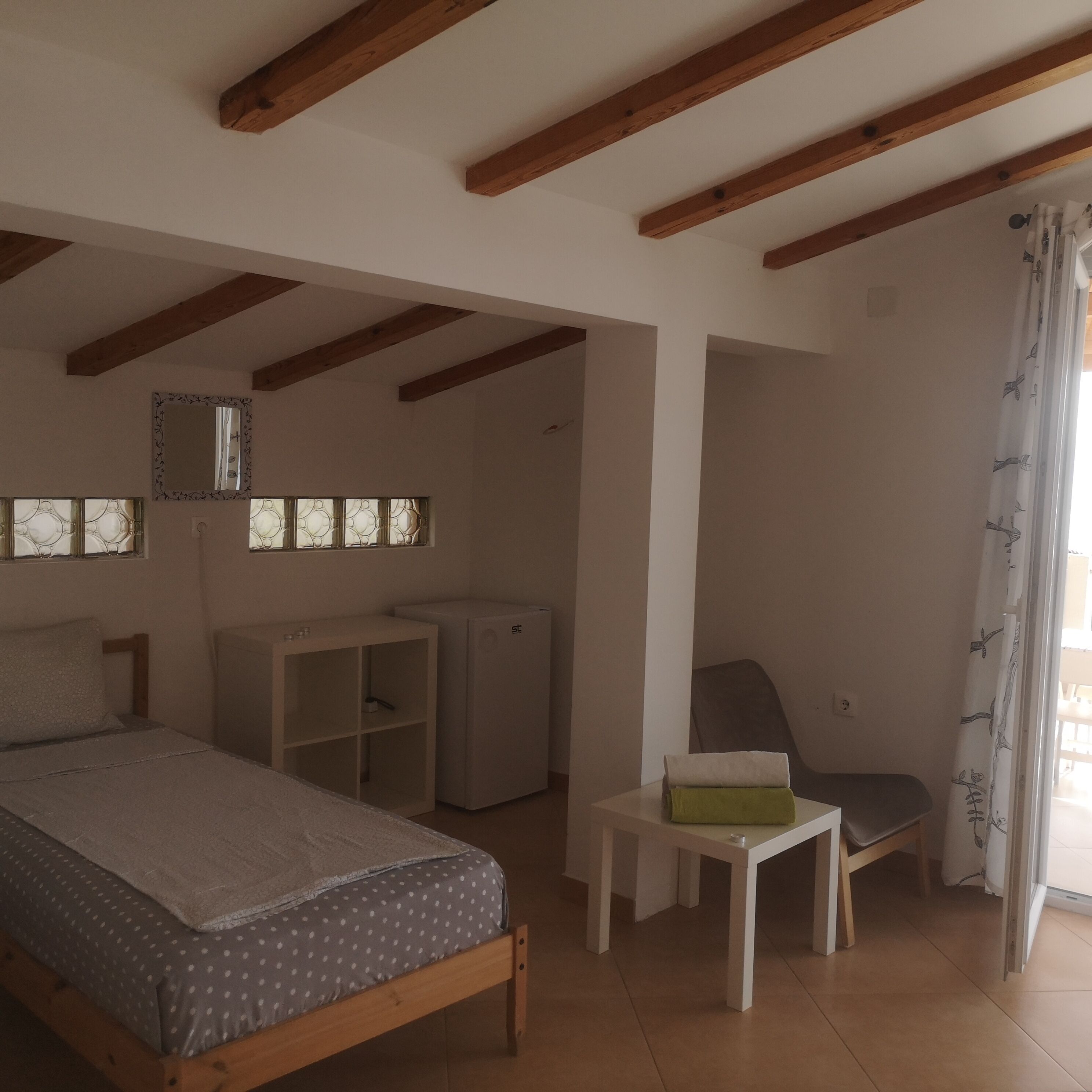 Un dormitorio con cama, escritorio, silla y armario.