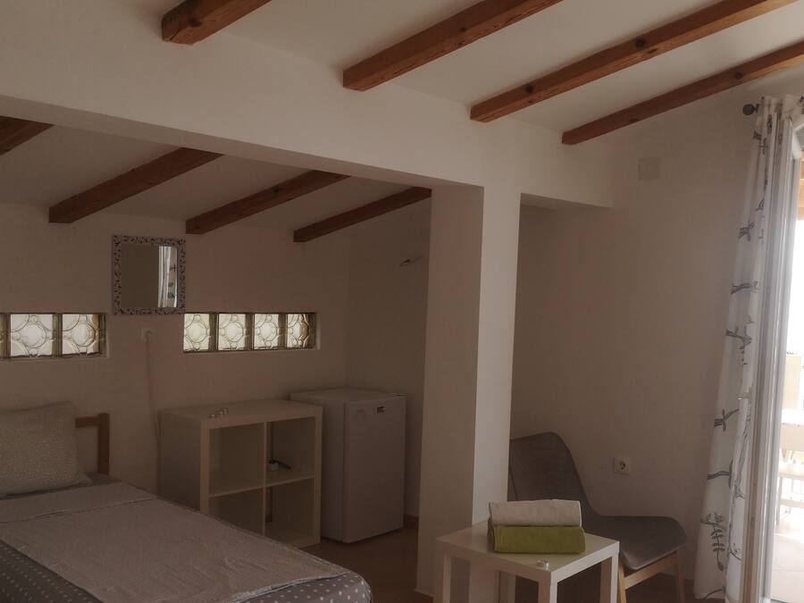 Un dormitorio con cama, escritorio, silla y armario.