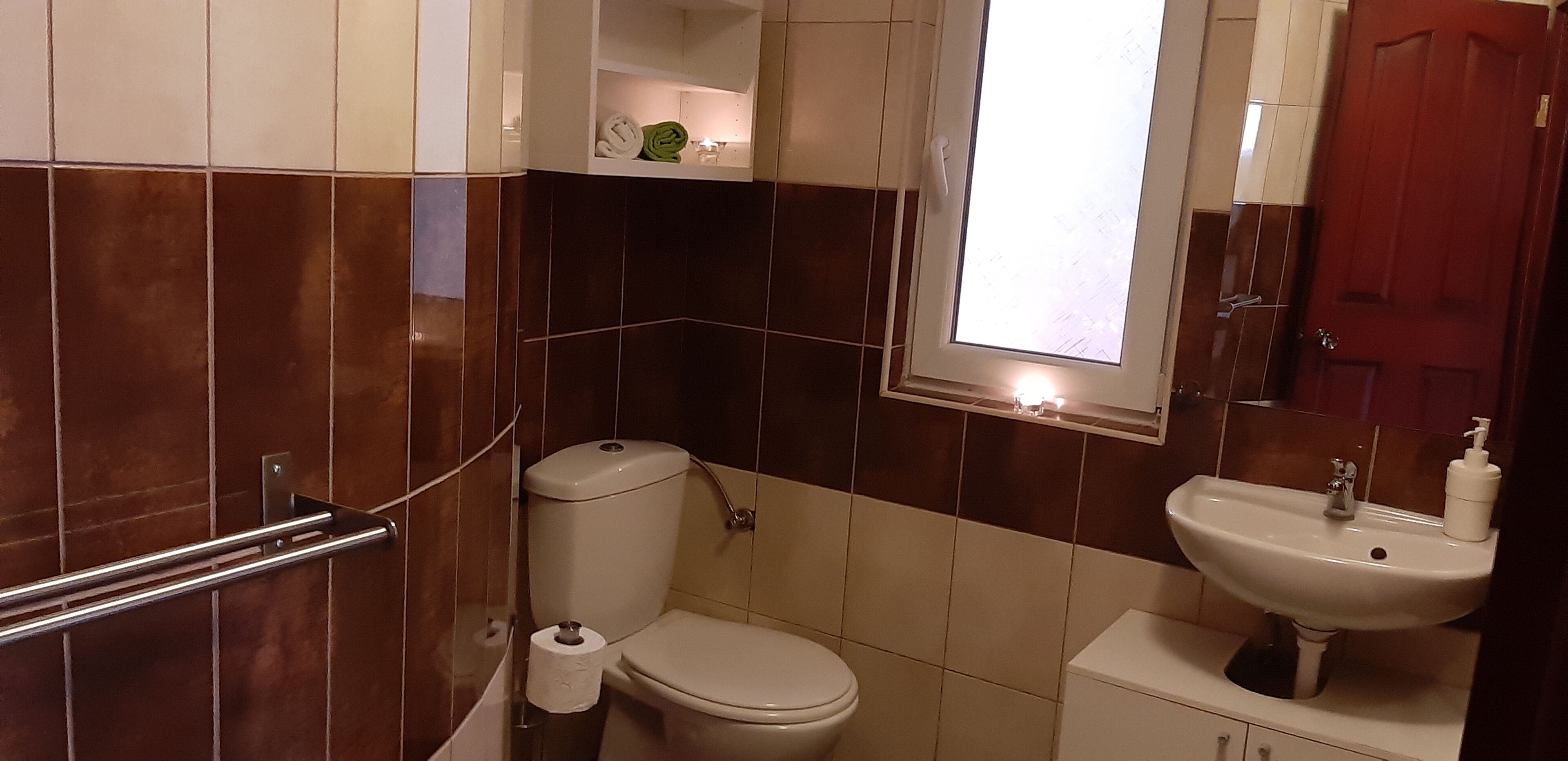 Baño con inodoro, lavabo y ventana.