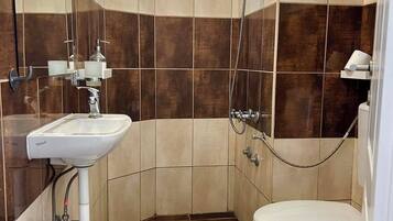 A small, modern bathroom with a shower, toilet, and sink.
