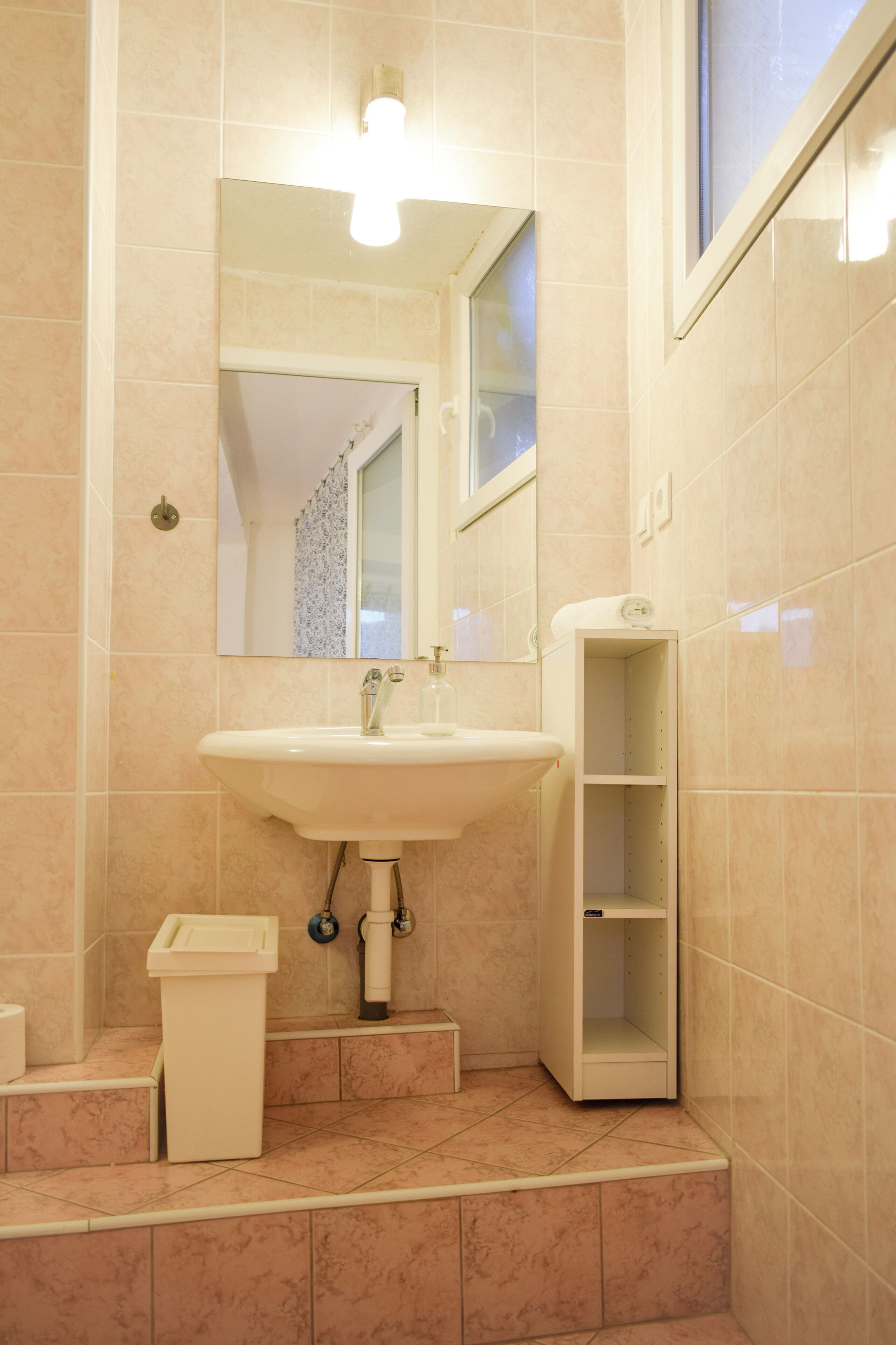 A bathroom with a sink, mirror, and a toilet.