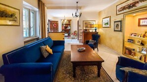 Un soggiorno con un divano blu, un tavolino in legno e un tappeto decorato.