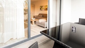 A modern room with a glass partition, a sofa, a small table, and a chair. - Appartements mit Blick auf die Spree in Lübben (Lübben)