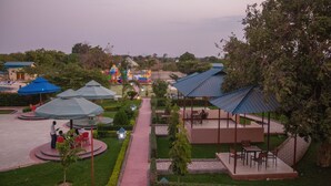 A resort with outdoor seating areas, covered walkways, and a central pathway. - Fantasy Village Hotel (Dodoma)