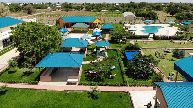 A resort with multiple buildings, a swimming pool, and well-maintained lawns. - Fantasy Village Hotel (Dodoma)