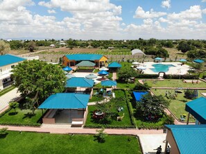 A resort with multiple buildings, a swimming pool, and well-maintained lawns. - Fantasy Village Hotel (Dodoma)