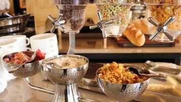 Una mesa de buffet con distintos recipientes y utensilios para servir.