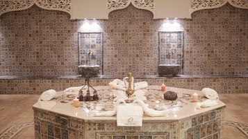 Experience the epitome of comfort in this beautifully appointed bathroom, featuring a central round sink, ornate tiles, and a decorative wall.