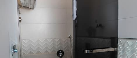 A modern shower enclosure with a glass door, a towel rack, and a showerhead.