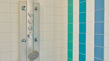 A shower with multiple control knobs and a handheld showerhead.