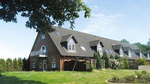 A large, multi-story house with a sloped roof, multiple windows, and a covered porch area. - Ferienwohnanlage Gut Bundhorst, Stolpe (Stolpe)