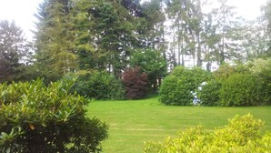 A well-maintained garden with a variety of trees and shrubs, a neatly trimmed lawn, and a clear sky. - Hotel Landhaus Wachendorf (Bruchhausen-Vilsen)