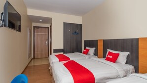A hotel room with two beds, a TV, a wardrobe, and a desk. - Capital O 89538 Ocean Hotel (Labuan)