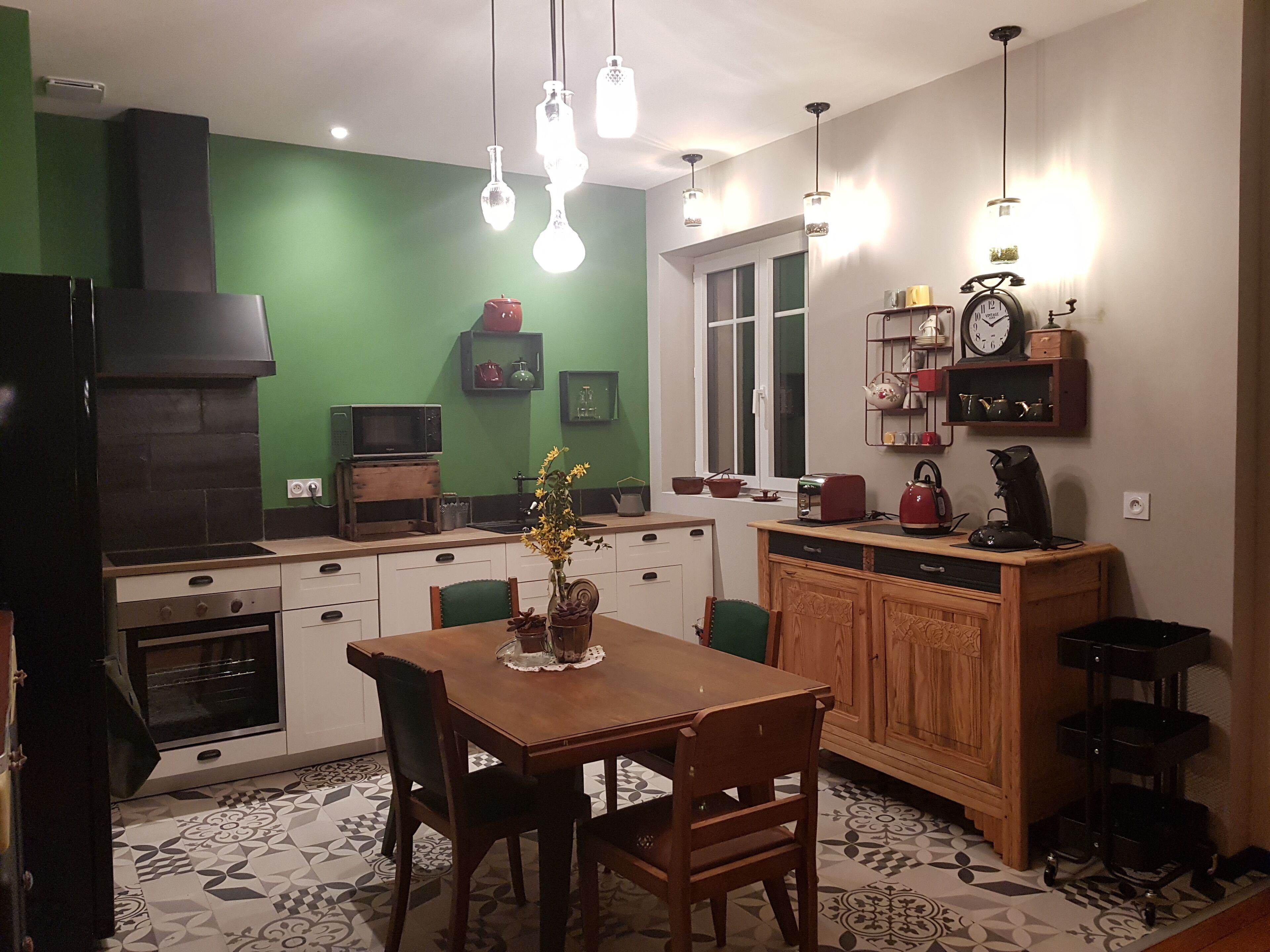 Una cocina con una mesa de comedor, sillas, microondas, estufa y pileta.