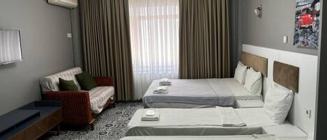 Habitación familiar, varias camas | 1 dormitorio, minibar, escritorio y cortinas opacas