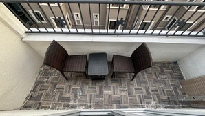 A balcony with wicker furniture, a table, and a railing. - Mara Suite Taxim (Istanbul)