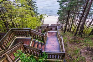 A wooden staircase leading to a beach, surrounded by trees.