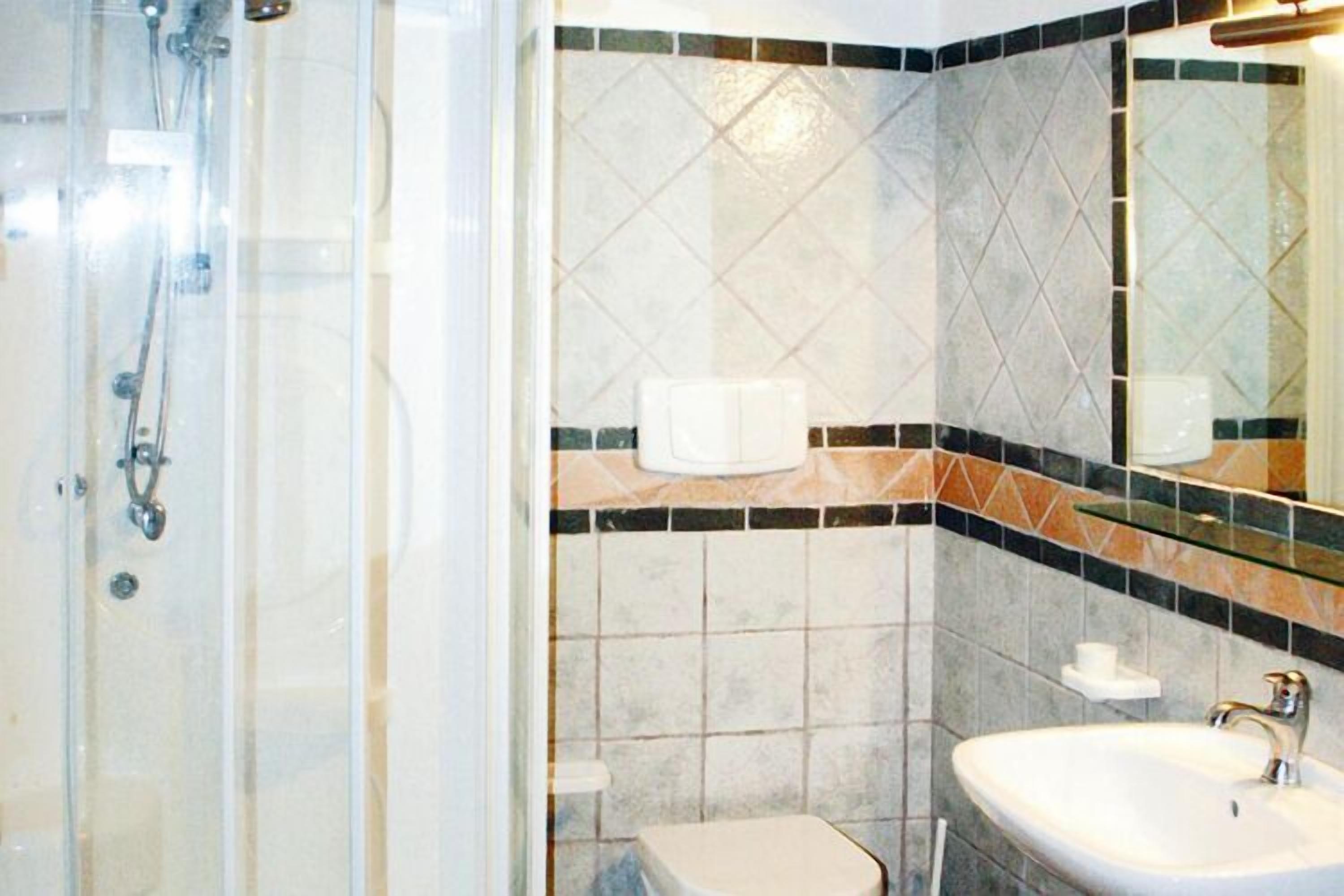 Un bagno con doccia vetrata, lavandino e WC.