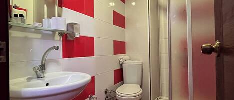 A bathroom with a sink, toilet, and glass-enclosed shower.